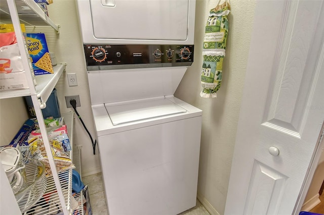 clothes washing area with stacked washing maching and dryer