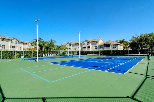 view of tennis court featuring basketball hoop