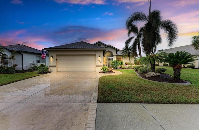 ranch-style home featuring a garage and a yard