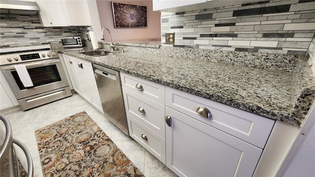 kitchen with white cabinetry, sink, exhaust hood, and appliances with stainless steel finishes