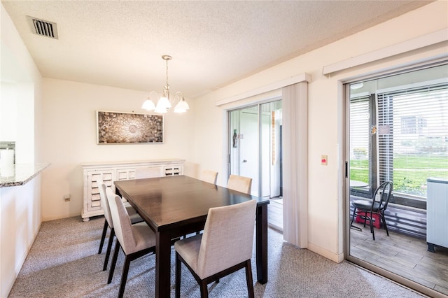 carpeted dining area with radiator heating unit, a healthy amount of sunlight, an inviting chandelier, and a textured ceiling