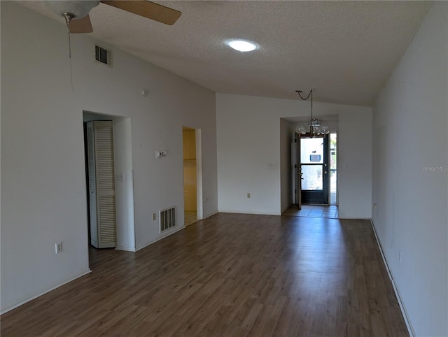 unfurnished room featuring ceiling fan, dark hardwood / wood-style flooring, a textured ceiling, and lofted ceiling