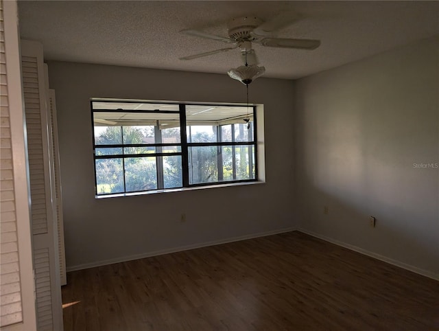 unfurnished room with ceiling fan, a textured ceiling, and dark hardwood / wood-style flooring