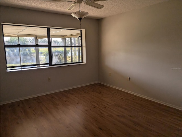 spare room with ceiling fan, a textured ceiling, and dark hardwood / wood-style floors