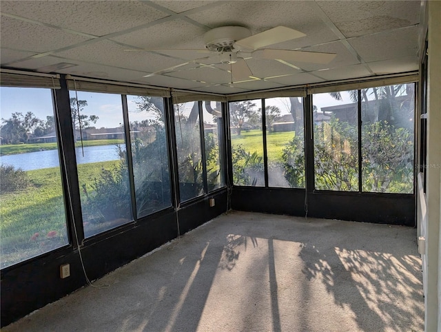 unfurnished sunroom featuring a drop ceiling, a water view, and ceiling fan