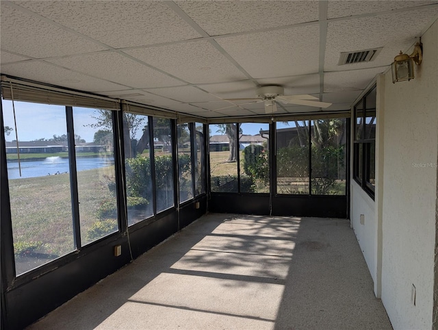 unfurnished sunroom with ceiling fan, a water view, and a paneled ceiling