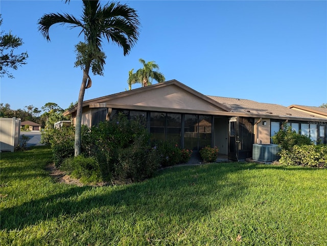 rear view of property with a lawn and central AC