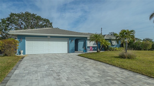 ranch-style home featuring a garage and a front lawn