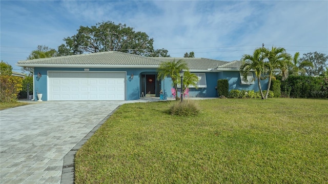 ranch-style house featuring a garage and a front lawn