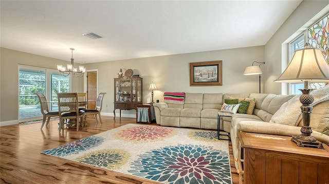 living room with an inviting chandelier and light wood-type flooring