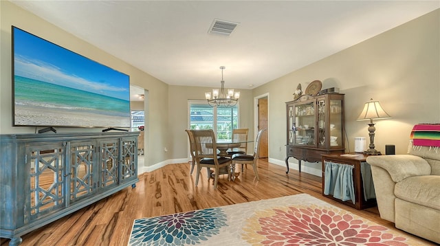 dining space featuring hardwood / wood-style floors and a chandelier