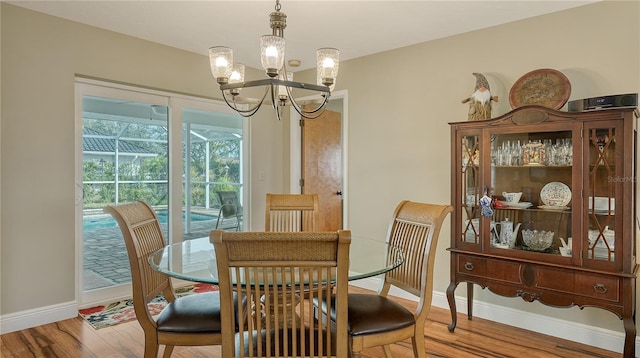 dining room with hardwood / wood-style flooring and a chandelier