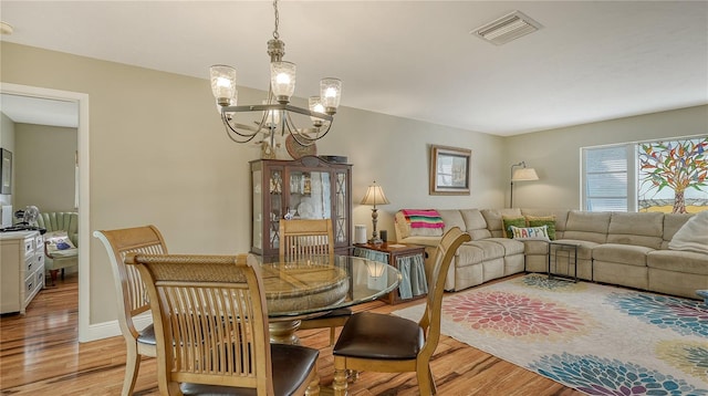 dining area featuring an inviting chandelier and light wood-type flooring