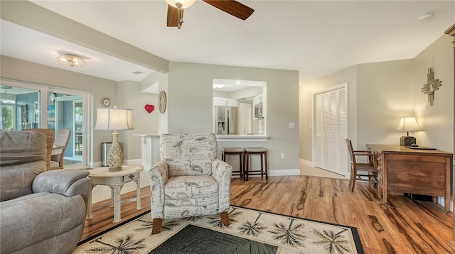 sitting room with wood-type flooring and ceiling fan