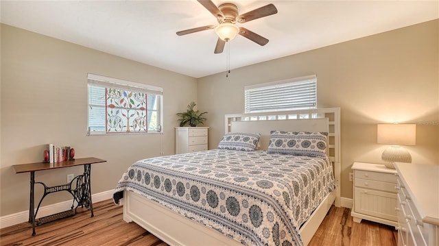 bedroom featuring multiple windows, ceiling fan, and light hardwood / wood-style floors