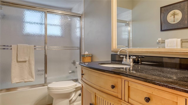 full bathroom featuring vanity, shower / bath combination with glass door, and toilet