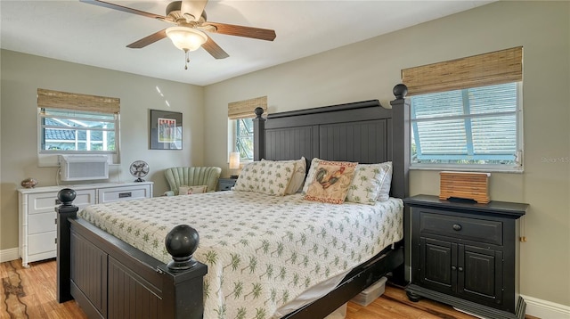 bedroom featuring ceiling fan, light hardwood / wood-style floors, and multiple windows