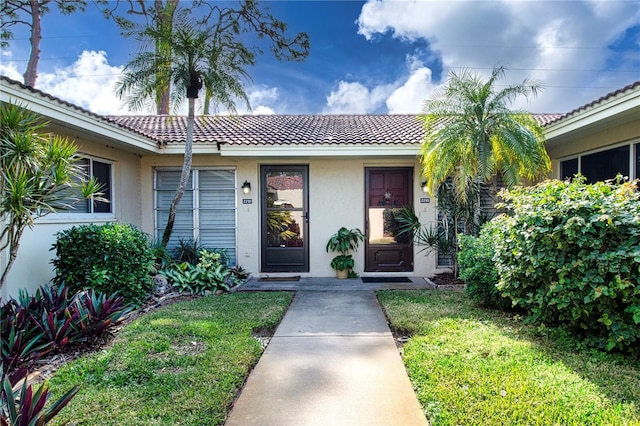 property entrance with a lawn