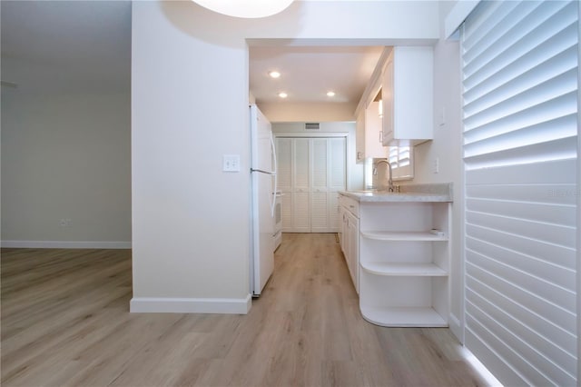 hallway with light wood-type flooring and sink