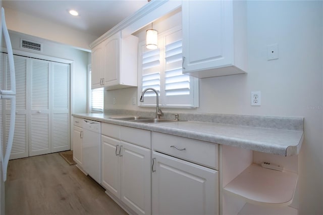 kitchen featuring white dishwasher, sink, white cabinets, and light hardwood / wood-style floors