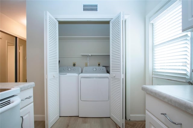 laundry area with light hardwood / wood-style floors and independent washer and dryer