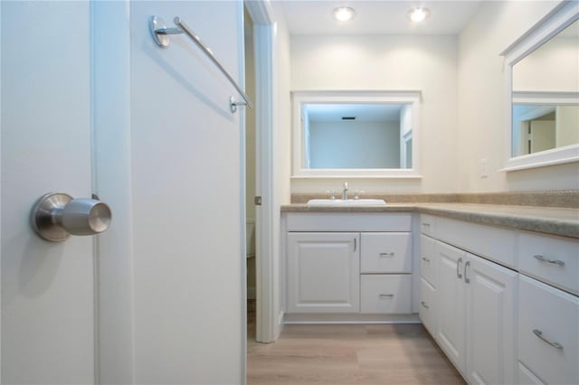 bathroom with hardwood / wood-style floors, toilet, and vanity