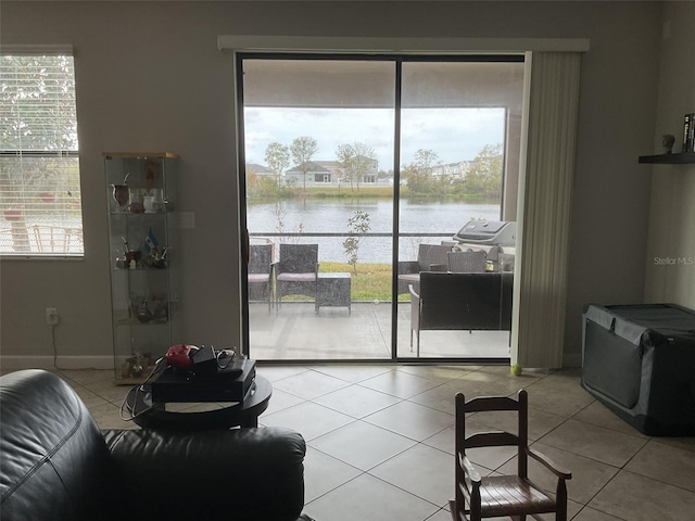 living room featuring a water view, light tile patterned floors, and a wealth of natural light