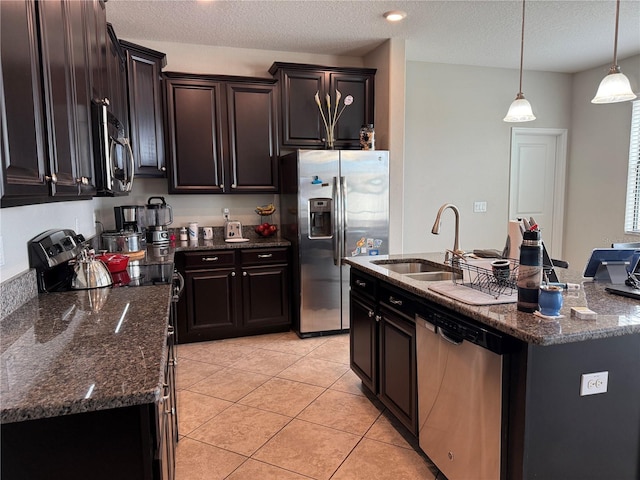 kitchen with sink, stainless steel appliances, an island with sink, and light tile patterned flooring