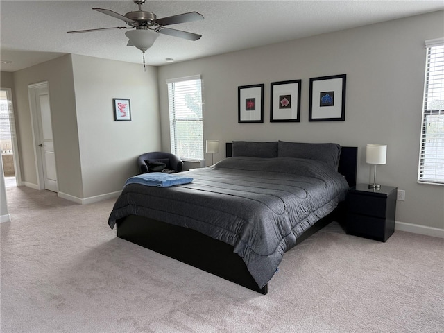 carpeted bedroom with multiple windows, a textured ceiling, and ceiling fan