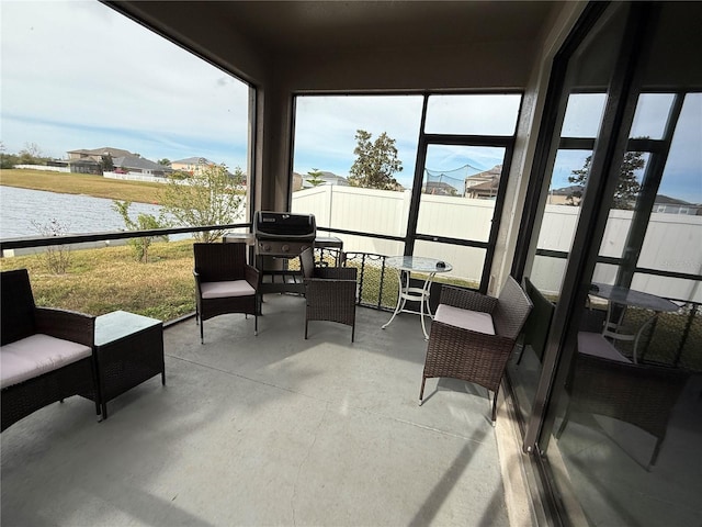 sunroom / solarium featuring a water view