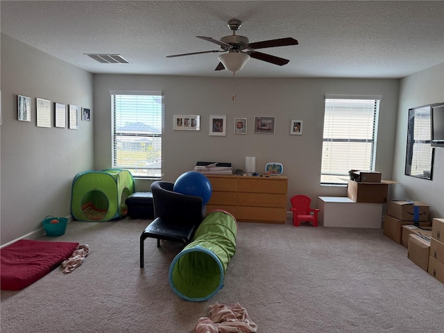 carpeted office featuring ceiling fan and a textured ceiling