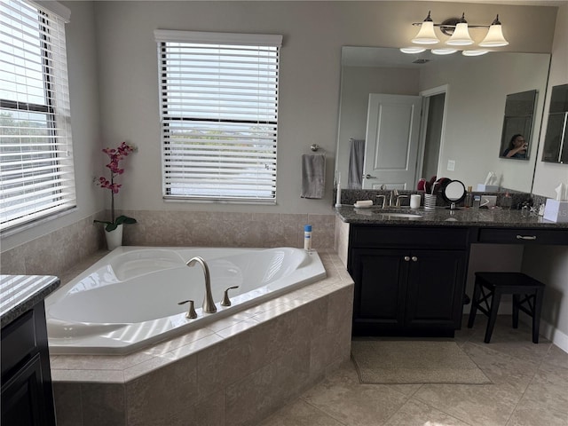 bathroom featuring a relaxing tiled tub, vanity, and tile patterned flooring