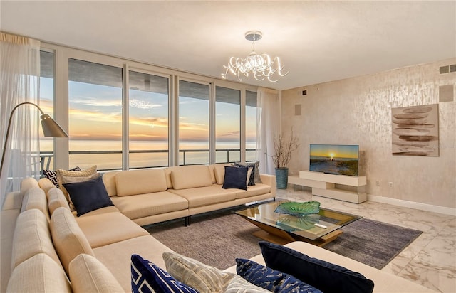 living room featuring a water view, plenty of natural light, and an inviting chandelier