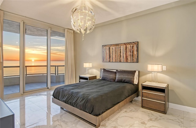 bedroom with a water view, a chandelier, and access to outside