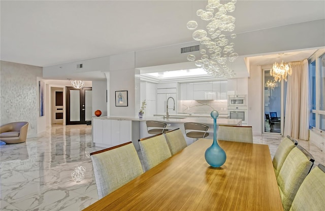 dining area featuring sink and a notable chandelier