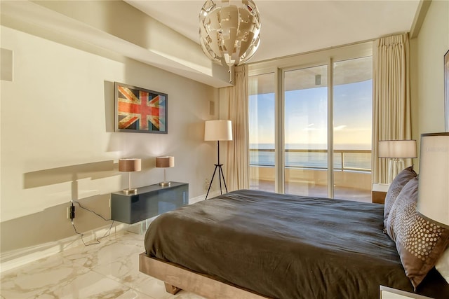 bedroom featuring a water view, an inviting chandelier, and access to outside