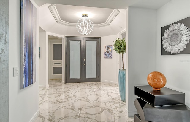 foyer entrance featuring french doors, crown molding, a chandelier, and a tray ceiling