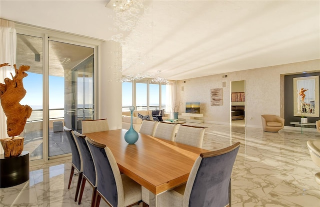 dining room with a water view and a chandelier