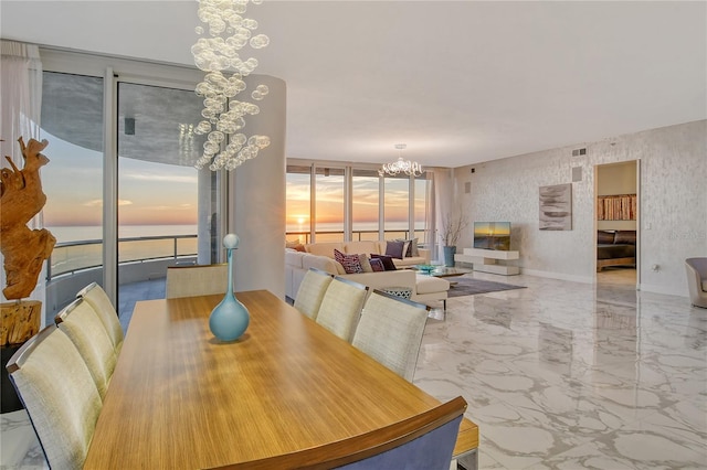 dining space featuring a water view and an inviting chandelier