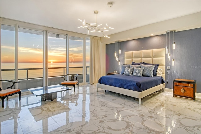 bedroom featuring an inviting chandelier, access to exterior, and a water view