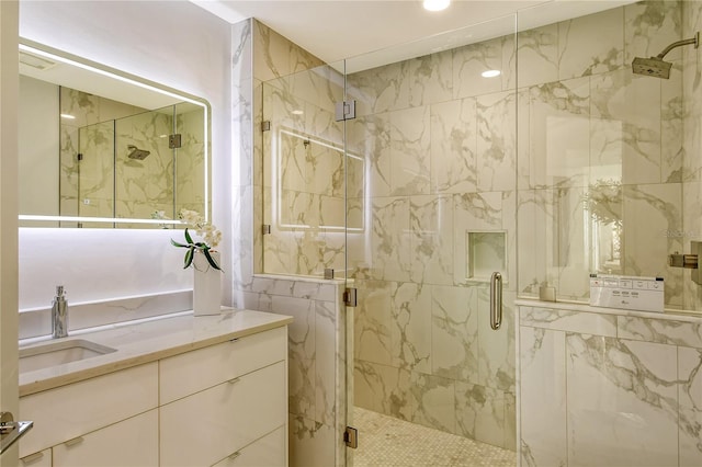 bathroom featuring vanity and a shower with door