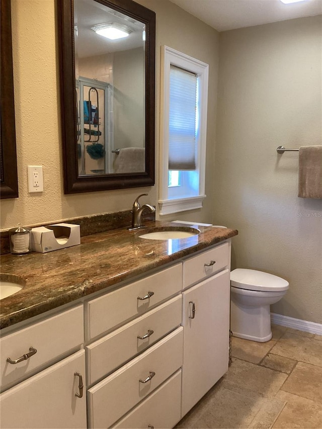 bathroom featuring walk in shower, vanity, and toilet