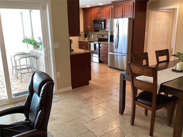 kitchen featuring tasteful backsplash, appliances with stainless steel finishes, and light stone counters