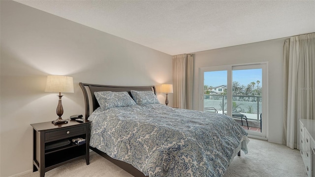 bedroom featuring a textured ceiling, light colored carpet, and access to exterior