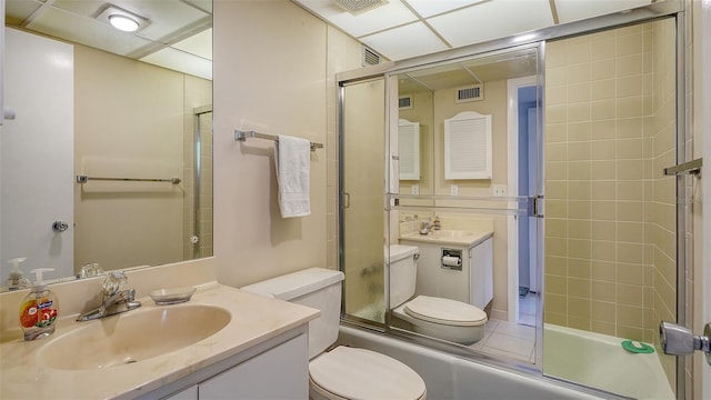 full bathroom with combined bath / shower with glass door, a paneled ceiling, toilet, and vanity