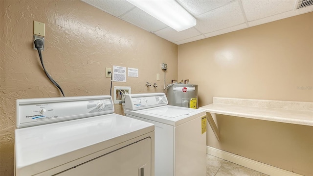 washroom with separate washer and dryer, light tile patterned floors, and water heater