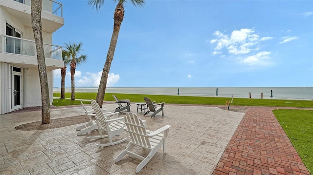 view of patio with a balcony and a water view