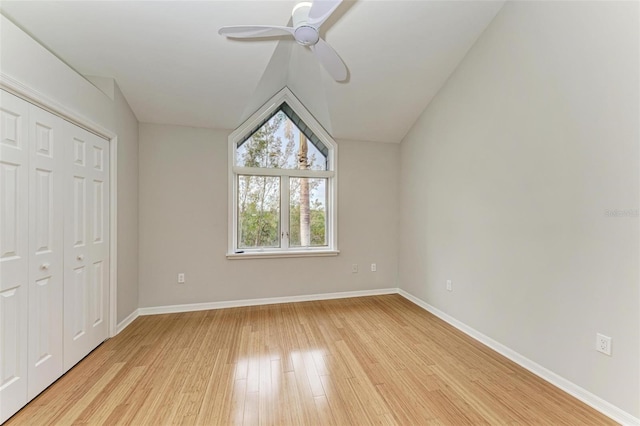 unfurnished bedroom with a closet, ceiling fan, light hardwood / wood-style floors, and lofted ceiling