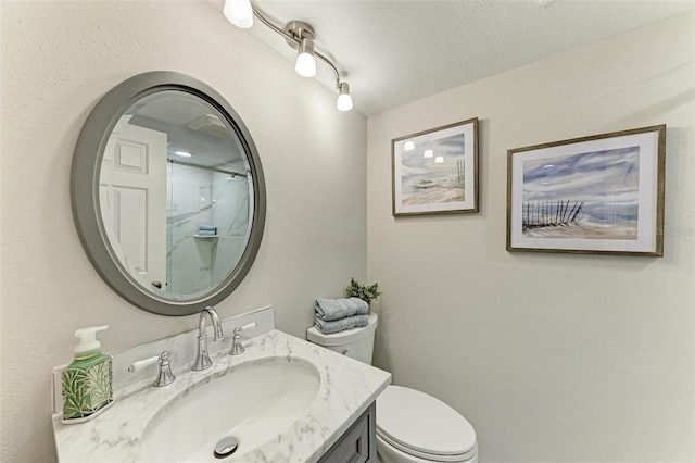 bathroom with a shower, a textured ceiling, toilet, and vanity