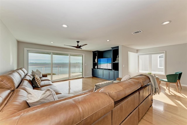 living room featuring light wood-style floors, baseboards, visible vents, and recessed lighting